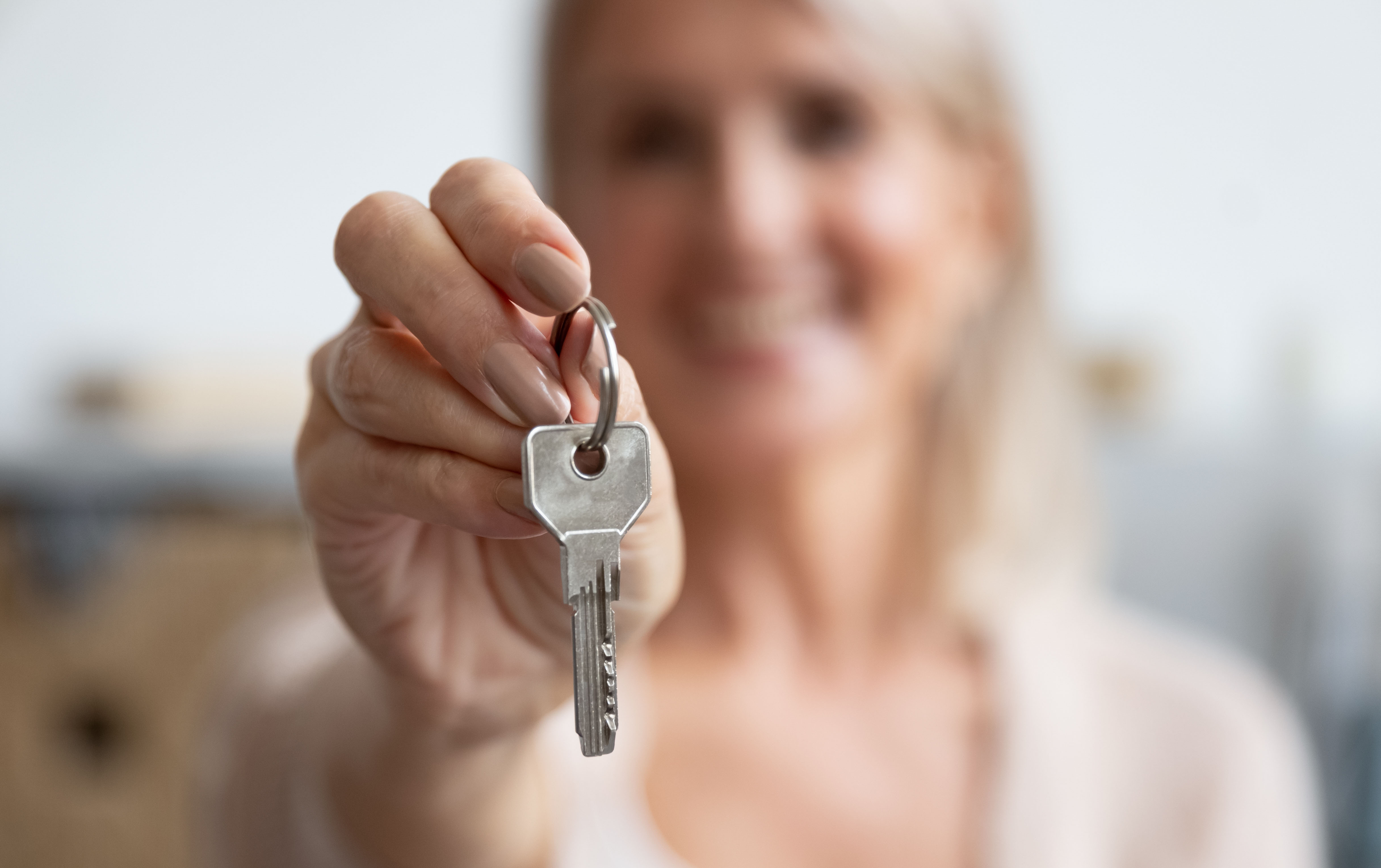A lady holding a house key 